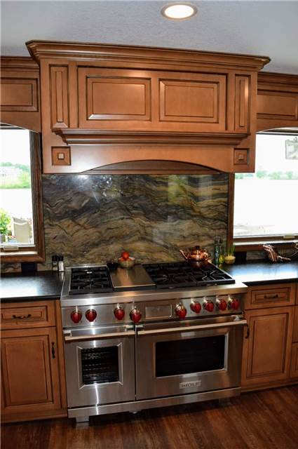 Stained and glazed maple cabinets - commercial range - commercial wood range hood - granite countertop and backsplash